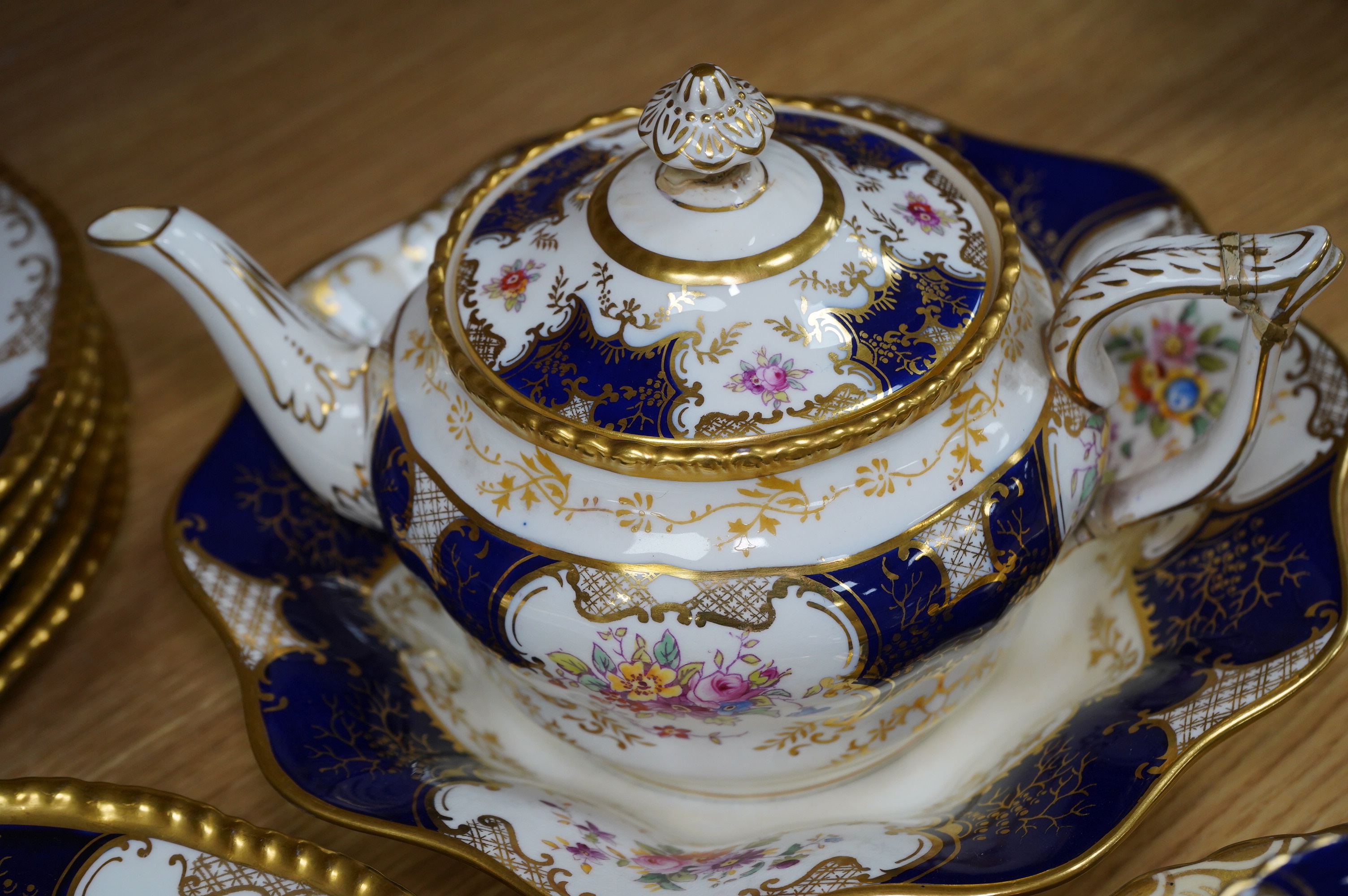 A late 19th/early 20th century Coalport blue and gilt bordered floral painted part tea and dessert service, largest 32cm wide. Condition - varies